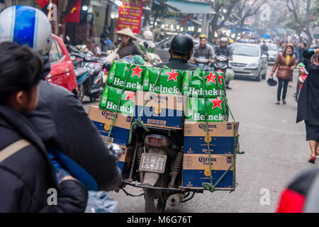 Un homme monte un scooter avec beaucoup de boîtes de bière attaché à l'arrière à Hanoi, Vietnam Banque D'Images