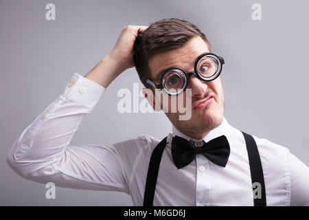 Close-up of a Young Man envisagée contre l'arrière-plan gris Banque D'Images