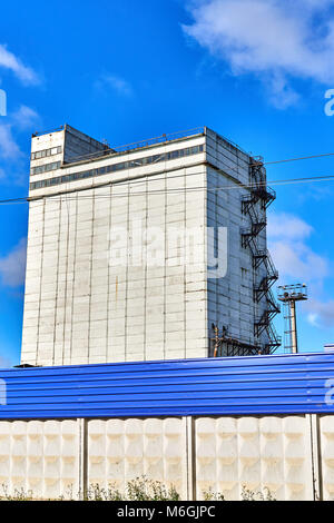 Construction de silo en béton avec échelle d'évacuation incendie sur façade blanche contre ciel bleu Banque D'Images