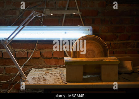 Ponceuse à disque d'établi avec lampe dans la poussière après le travail en atelier Banque D'Images