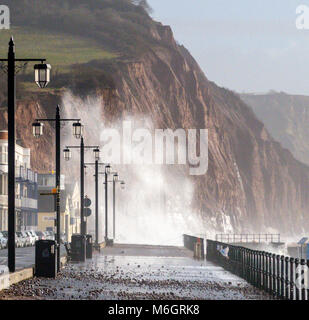 Sidmouth, Devon, 4th mars 18 pas encore terminé - tempête Emma livres dans Sidmouth, avec des vagues qui s'élèvent au-dessus des maisons et des hôtels en bord de mer. Une forte hausse des températures, combinée à une forte encage de l'eau de mer, a enlevé toute trace de neige qui a couvert l'Esplanade jeudi et vendredi. Banque D'Images