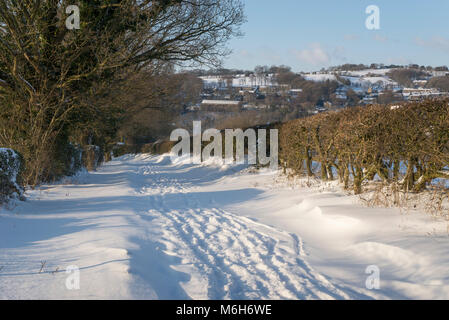 La neige profonde sur un chemin de campagne dans la campagne anglaise. Banque D'Images