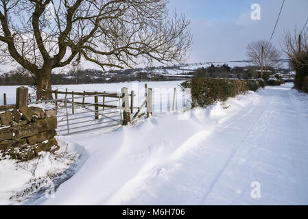 La neige profonde sur un chemin de campagne dans la campagne anglaise. Banque D'Images