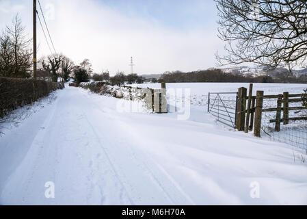 La neige profonde sur un chemin de campagne dans la campagne anglaise. Banque D'Images