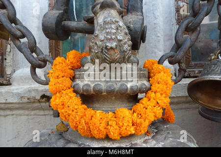 Photo d'une statue avec une guirlande faite avec des fleurs orange au Stupa de Boudhanath, Katmandou, Népal Banque D'Images