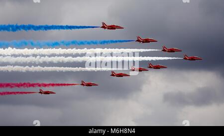 La flèche rouge avec il y célèbre rouge blanc et bleu de traînées de fumée à la fantastique avec le sombre ciel d'orage dans l'arrière-plan Banque D'Images