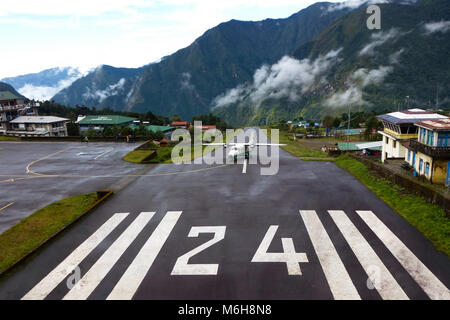 Petit avion à l'atterrissage à l'aéroport Tenzing-Hillary" 'à Lukla sur un jour nuageux, Camp de base de l'Everest trek, au Népal Banque D'Images