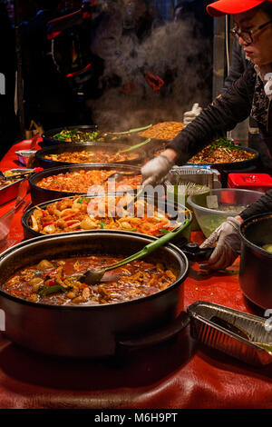 LONDON, UK-FEBR 11,2018 : Malaysian cook est l'agitation dans la cuisson des aliments et la vapeur dans leurs pots at a market stall. Banque D'Images