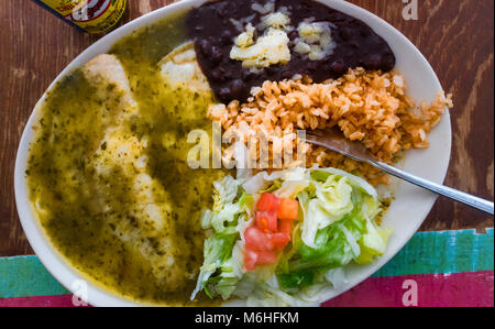 Les enchiladas suizas avec les haricots noirs, le riz brun et salade Banque D'Images