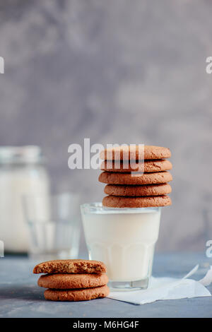 Les cookies dans une pile sur un verre de lait. Petit déjeuner santé minimaliste concept avec copie espace. Banque D'Images