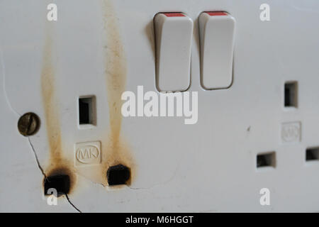 Une prise murale électrique causé par une surcharge avec un trop grand nombre d'appareils branchés. Banque D'Images