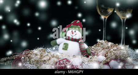 Fun toy snowman et deux verres de champagne on a black background Banque D'Images