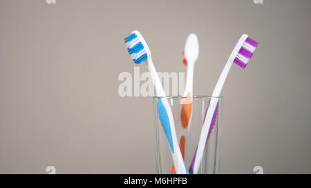 Trois brosses à dents de couleur sur étagère dans salle de bains, prendre soin de la cavité orale Banque D'Images