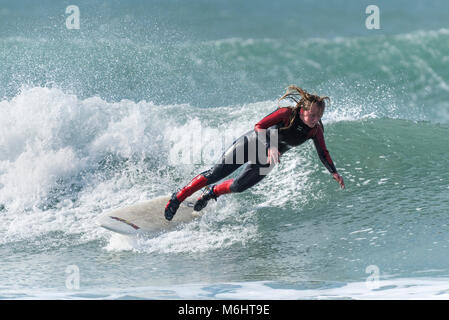 Un surfeur chute depuis une planche de surf dans des conditions hivernales à froid dans Fistral Newquay Cornwall. Banque D'Images