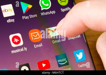 Gros plan de l'application Gmail sur un smartphone sélectionné par le doigt d'une femme pointant vers l'application sur le écran du téléphone cellulaire Banque D'Images