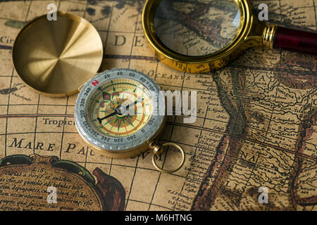 Boussole rétro avec carte ancienne et la loupe closeup Banque D'Images
