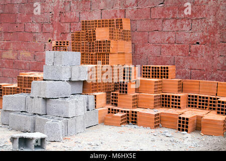 Des piles de briques rouges et gris sur un chantier Banque D'Images