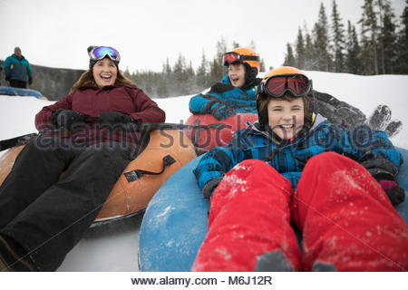 Mère et fils heureux tubes intérieurs dans la neige à tube park