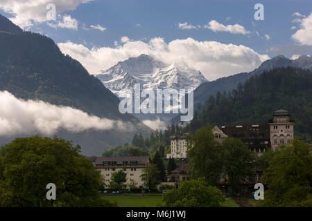 Couvert de neige des Alpes suisses Jungfrau Interlaken Bern Suisse été fond de ciel bleu nuages bas en vallée Linder Grand Hotel Beau Rivage resort Banque D'Images