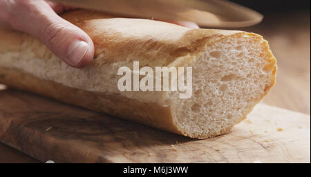 Baguette man slicing Gros plan sur planche de bois Banque D'Images