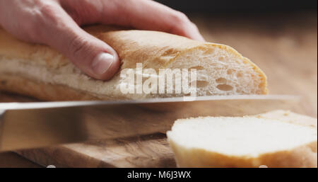 Baguette man slicing Gros plan sur planche de bois Banque D'Images