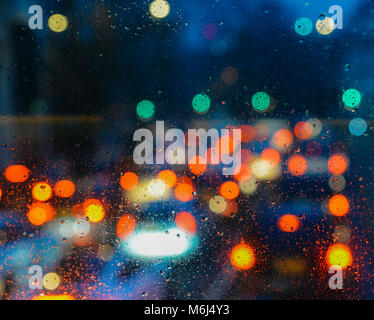 Résumé fond mélancolique émotionnelle avec lumières bokeh flou artistique à Londres, Royaume-Uni derrière gouttes de pluie dans la fenêtre en verre, se concentrer sur quelques gouttes en raison de la faible profondeur de champ Banque D'Images