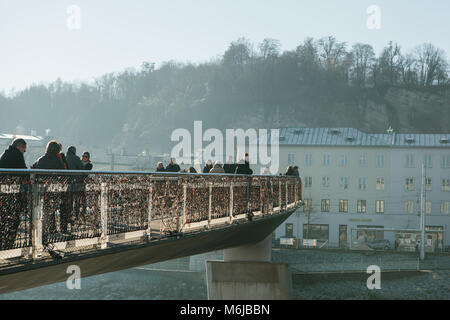 Autriche, Salzbourg, le 1er janvier 2017 : la passerelle pour piétons relie l'ancienne et de la nouvelle ville. Les piétons marchent sur le pont. La pendaison de cadenas sur le pont est une tradition. Banque D'Images