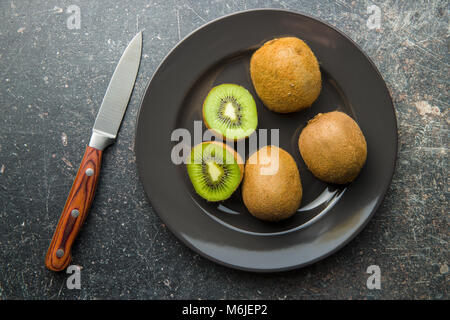 Les kiwis coupés en deux sur la plaque. Banque D'Images