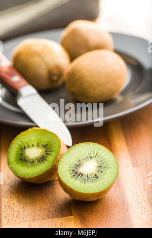 Les kiwis coupés en deux sur la table en bois. Banque D'Images