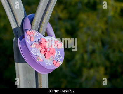 Blocage de mariage pourpre forme de cœur avec une rose fleurs et perles blanches sur le pont metall Banque D'Images