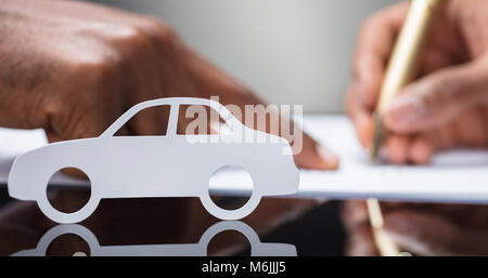 Signature de l'accord de prêt de voiture Contrat avec silhouette de voiture sur verre 24 Banque D'Images