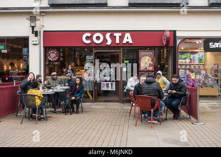 Malgré le temps froid, les gens continuent de s'asseoir à l'extérieur du Café Costa à Windsor, pour socialiser et profiter d'un café ou d'autres rafraîchissements. Banque D'Images