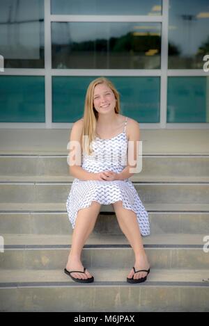 Teenage girl sitting on High School comme suit Banque D'Images