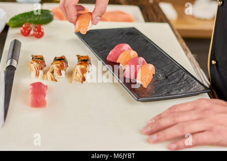 Sushi Chef putting sur plaque noire. Banque D'Images