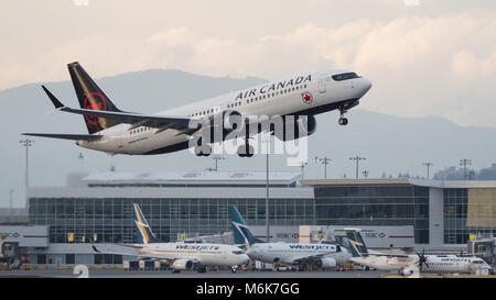 Richmond, Colombie-Britannique, Canada. 4e Mar, 2018. Un Air Canada Boeing 737-8 MAX (C-FSDQ) étroit à couloir unique-body twin-jet airliner décolle de l'Aéroport International de Vancouver. Les avions de WestJet Airlines, Air Canada's concurrent direct, peut être vu dans l'arrière-plan à l'aéroport terminal domestique. Credit : Bayne Stanley/ZUMA/Alamy Fil Live News Banque D'Images