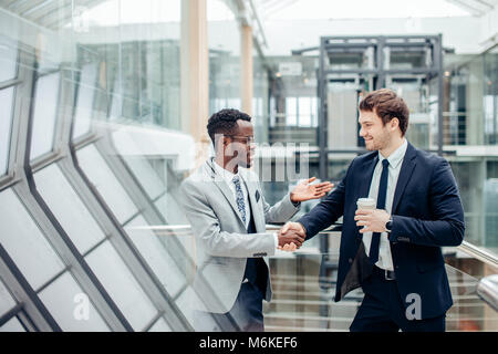 Deux hommes d'multiraciale handshaking in modern office pour fin de grande Banque D'Images