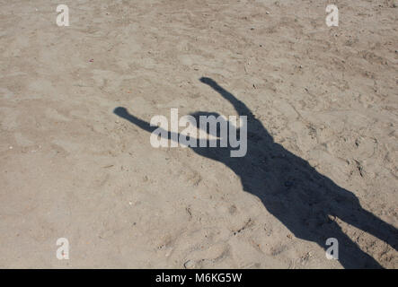 Ombre de l'homme faisant signer sur fond de sable le socialisme. Yannick Noah est un symbole de solidarité et de soutien. Il est également utilisé comme un hommage à l'unité express Banque D'Images