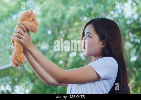 Teen girl Playing with bear toy with nature background. Banque D'Images