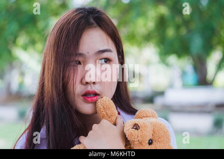 Teen girl Playing with bear toy with nature background. Banque D'Images