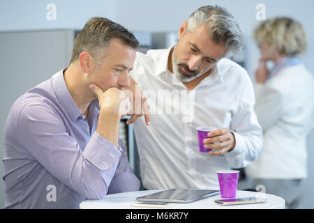 Les hommes de boire du café en conserve dans une pause Banque D'Images