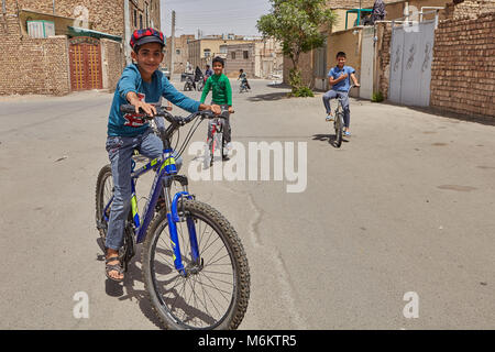 Kashan, Iran - avril 27, 2017 : les garçons d'âge scolaire de la bicyclette à l'extérieur, dans un quartier résidentiel de la ville. Banque D'Images