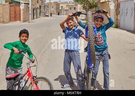 Kashan, Iran - avril 27, 2017 : les enfants mâles iraniens jouent dans une rue déserte dans un trimestre de faible hauteur des immeubles privés à la périphérie de la ville Banque D'Images