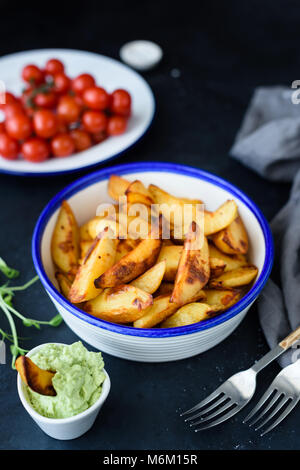 Pommes de terre rôties aux épices dans un bol sur fond sombre. Selective focus Banque D'Images