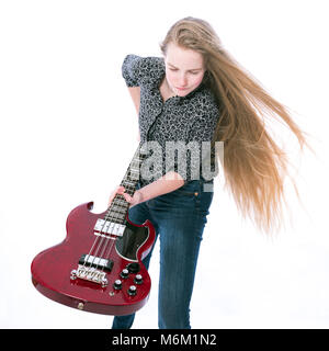 Teen blonde girl et guitare basse contre fond blanc en studio Banque D'Images