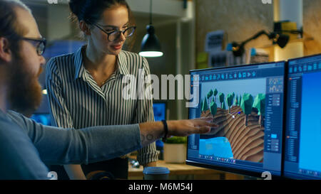 Des entretiens avec les développeurs de jeux de sexe masculin féminin artistique concepteur de niveaux. Deux écrans montrent jeu totalement original. Ils travaillent dans un bureau de création Loft. Banque D'Images