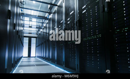 Shot de la collaboration d'un centre de données avec des rangées de serveurs en rack. Les gens à pied et y travaillent, ils sont flous en mouvement. L'exposition à long shot. Banque D'Images