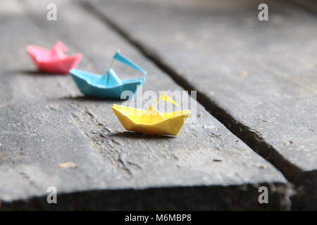Ensemble de bateaux origami multicolores sur table en bois. Les bateaux de papier. Banque D'Images