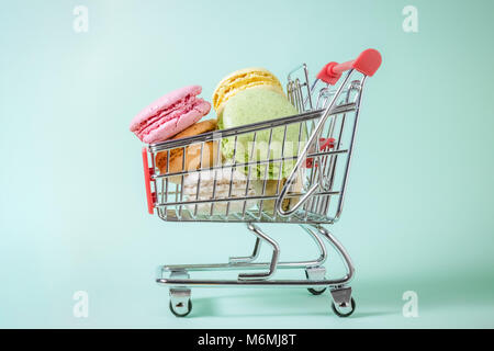 Studio photo de macarons en petit panier métal sur fond vert. Concept minimal. Banque D'Images