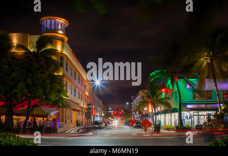 Ocean Drive à Miami dans la nuit avec des couleurs de la rue. Voitures qui passent par la création de lignes de lumière pendant une longue exposition. Palms hotel, en arrière-plan. Banque D'Images