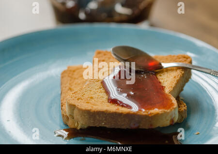 Tartiner sur des toasts Confiture de cerises dans l'assiette bleue Banque D'Images